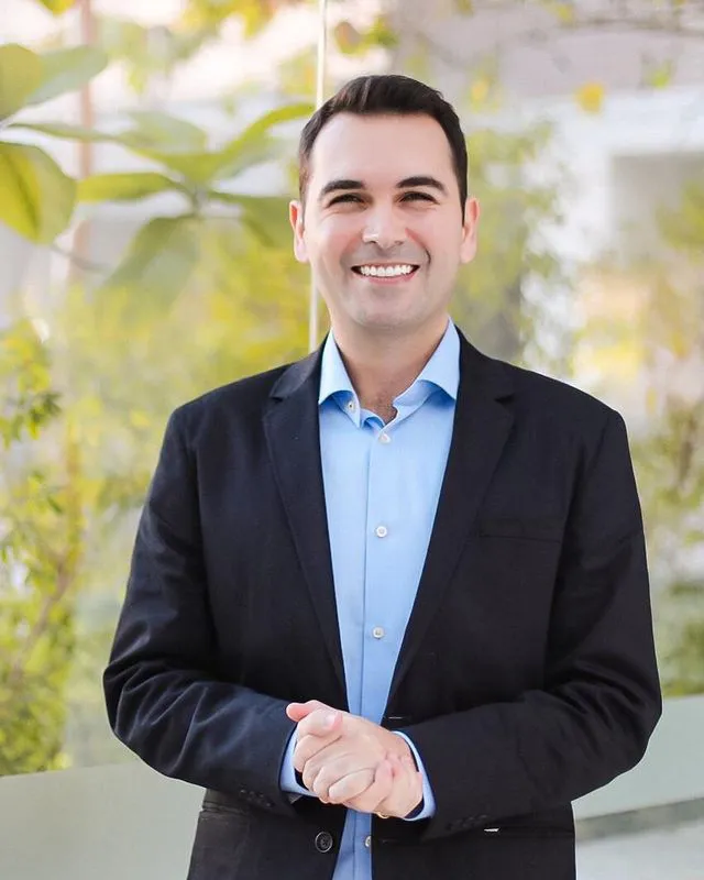 Júlio Domingos, consultor empresarial, de blazer escuro e camisa azul, sorrindo
